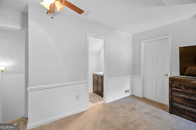 70 Otara Woods Ct, Newnan, GA 30263 - unfurnished bedroom with light colored carpet, wainscoting, connected bathroom, and ceiling fan