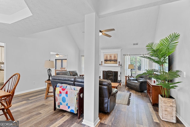 70 Otara Woods Ct, Newnan, GA 30263 - living room with ceiling fan, wood finished floors, vaulted ceiling, a fireplace with raised hearth, and baseboards