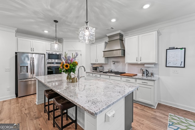 2036 Jefferson Hall Dr, Monroe, GA 30656 - kitchen featuring appliances with stainless steel finishes, custom range hood, white cabinetry, tasteful backsplash, and a breakfast bar