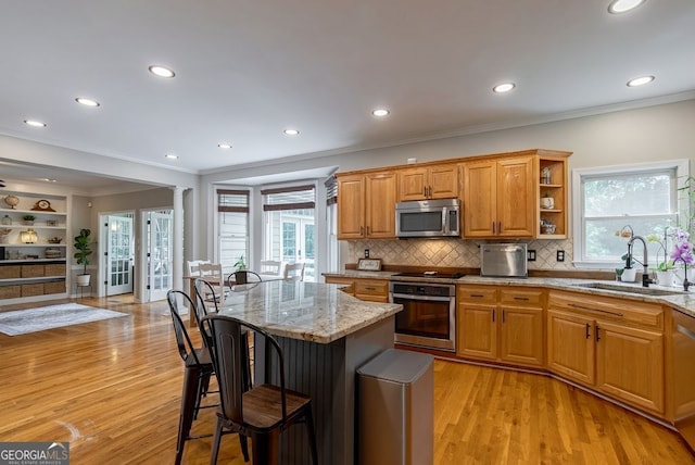 405 Woodbrook Way, Lawrenceville, GA 30043 - kitchen featuring appliances with stainless steel finishes, a sink, a kitchen breakfast bar, light wood-style flooring, and light stone counters
