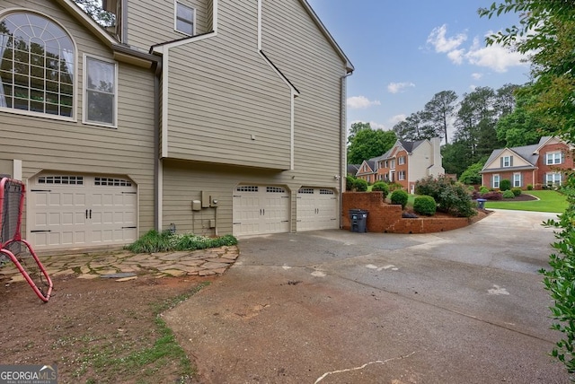 405 Woodbrook Way, Lawrenceville, GA 30043 - view of side of home with a garage, a residential view, and concrete driveway