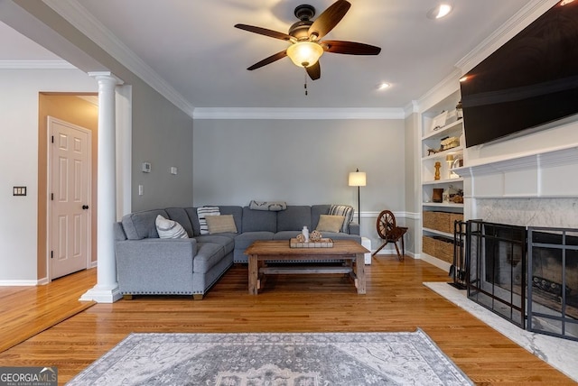 405 Woodbrook Way, Lawrenceville, GA 30043 - living area with ceiling fan, wood finished floors, built in shelves, baseboards, and crown molding