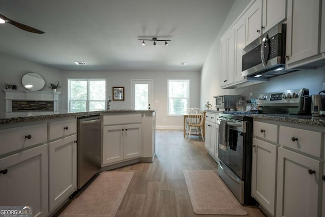 35 Westwood St, Danielsville, GA 30633 - kitchen featuring stainless steel appliances, light wood finished floors, stone counters, and a ceiling fan