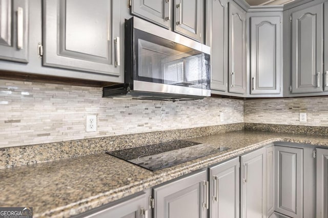 107 Julee Emilyn Dr, Bonaire, GA 31005 - kitchen featuring gray cabinets, stainless steel microwave, black electric cooktop, and backsplash