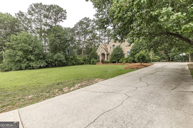 107 Julee Emilyn Dr, Bonaire, GA 31005 - view of green lawn with driveway and view of wooded area