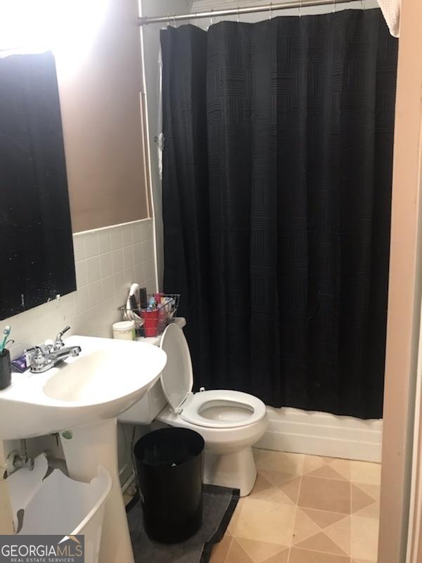 125 Jones St, Summerville, GA 30747 - bathroom with toilet, tile walls, curtained shower, and a wainscoted wall