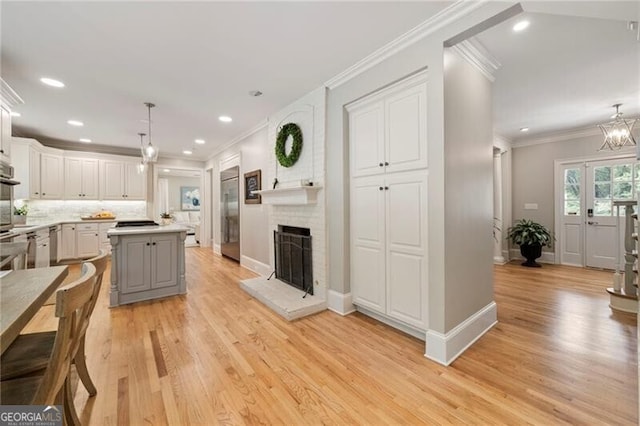 3894 Land O Lakes Dr NE, Atlanta, GA 30342 - kitchen with stainless steel appliances, light wood-style floors, decorative backsplash, white cabinets, and ornamental molding