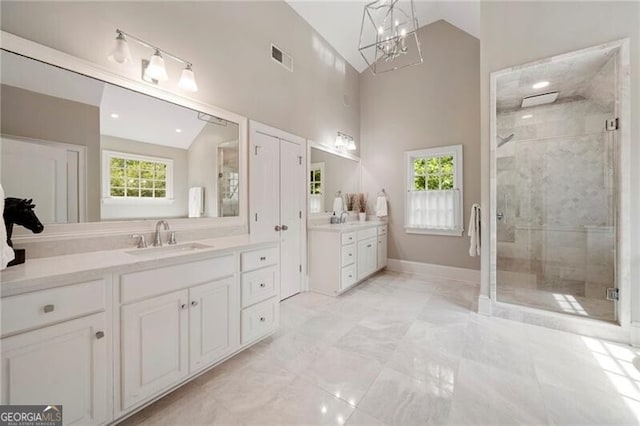3894 Land O Lakes Dr NE, Atlanta, GA 30342 - bathroom featuring two vanities, a stall shower, high vaulted ceiling, a chandelier, and marble finish flooring