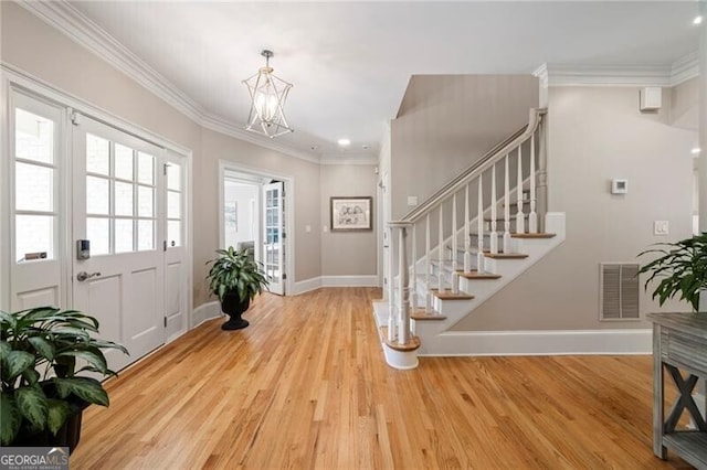 3894 Land O Lakes Dr NE, Atlanta, GA 30342 - entryway with wood finished floors, a chandelier, stairway, crown molding, and recessed lighting