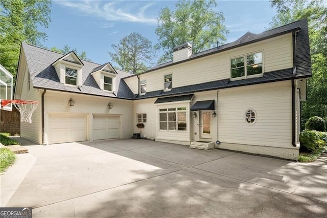 3894 Land O Lakes Dr NE, Atlanta, GA 30342 - view of front facade with concrete driveway, a chimney, an attached garage, and a shingled roof