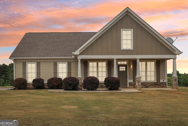 625 Henderson Mill Rd, Covington, GA 30014 - view of front of house featuring board and batten siding, a front yard, stone siding, covered porch, and roof with shingles