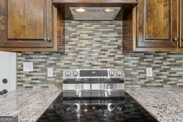 625 Henderson Mill Rd, Covington, GA 30014 - kitchen featuring electric range, tasteful backsplash, light stone counters, and dark brown cabinetry