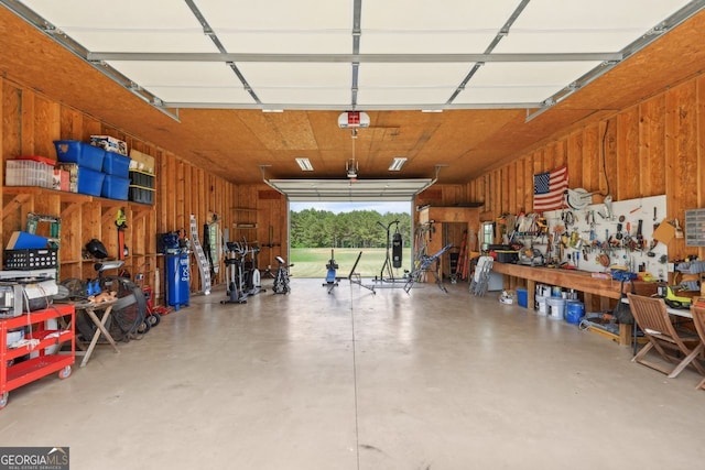 625 Henderson Mill Rd, Covington, GA 30014 - garage featuring wooden walls, a workshop area, and a garage door opener