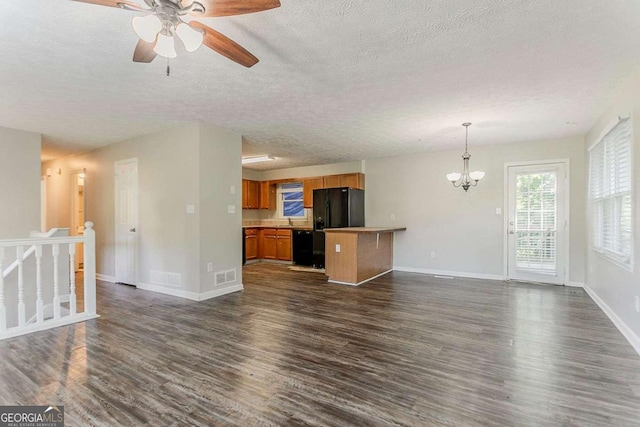 42 Breckenridge Dr, Powder Springs, GA 30127 - unfurnished living room featuring dark wood-style floors, a textured ceiling, a chandelier, a ceiling fan, and baseboards