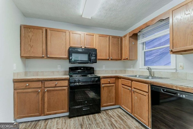 42 Breckenridge Dr, Powder Springs, GA 30127 - kitchen featuring black appliances, a sink, light wood-type flooring, and a textured ceiling