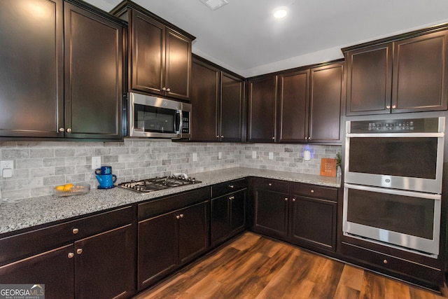 1243 Polk Xing, Mcdonough, GA 30252 - kitchen with stainless steel appliances, dark wood finished floors, light stone counters, and tasteful backsplash