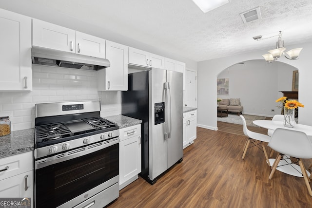 4941 Lighthouse Pointe, Acworth, GA 30101 - kitchen with appliances with stainless steel finishes, under cabinet range hood, arched walkways, white cabinets, and decorative backsplash