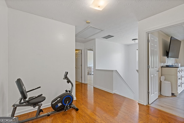 1450 Steam Engine Way NE, Conyers, GA 30013 - workout area with attic access, wood finished floors, and a textured ceiling