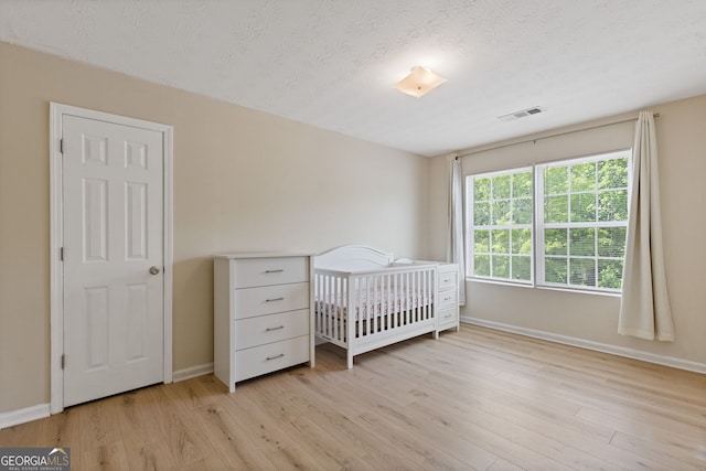 1450 Steam Engine Way NE, Conyers, GA 30013 - bedroom featuring light wood-type flooring and a textured ceiling