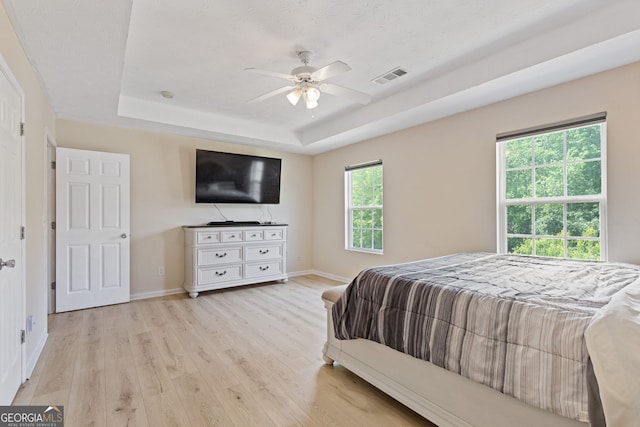 1450 Steam Engine Way NE, Conyers, GA 30013 - bedroom featuring a tray ceiling, light wood-style floors, and ceiling fan