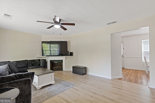 1450 Steam Engine Way NE, Conyers, GA 30013 - living room featuring ceiling fan, wood finished floors, a fireplace, and a textured ceiling