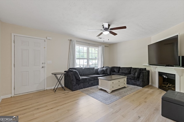 1450 Steam Engine Way NE, Conyers, GA 30013 - living room featuring ceiling fan, light wood-style floors, a textured ceiling, and a fireplace