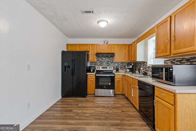 1450 Steam Engine Way NE, Conyers, GA 30013 - kitchen with black appliances, decorative backsplash, under cabinet range hood, light countertops, and a textured ceiling