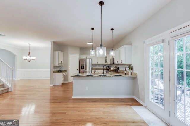 2725 Sedgeview Way, Buford, GA 30519 - kitchen with stainless steel appliances, backsplash, white cabinetry, a peninsula, and light wood finished floors