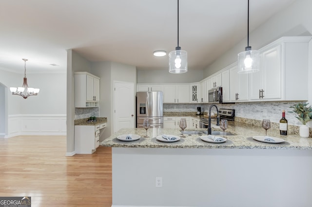 2725 Sedgeview Way, Buford, GA 30519 - kitchen featuring stainless steel appliances, white cabinetry, a peninsula, light stone countertops, and decorative backsplash