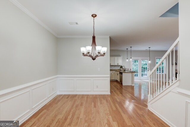 2725 Sedgeview Way, Buford, GA 30519 - empty room with light wood-type flooring, a chandelier, wainscoting, stairway, and a decorative wall