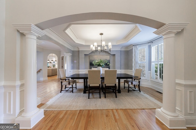 2101 Hunters Green Dr, Lawrenceville, GA 30043 - dining area featuring arched walkways, light wood-style floors, a chandelier, a raised ceiling, and crown molding