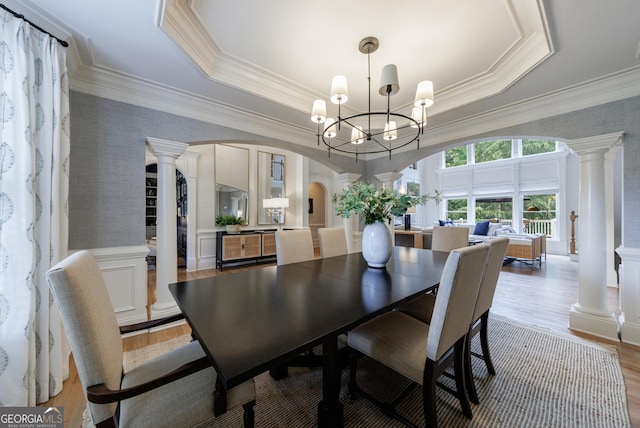 2101 Hunters Green Dr, Lawrenceville, GA 30043 - dining area with arched walkways, a tray ceiling, decorative columns, wood finished floors, and wallpapered walls