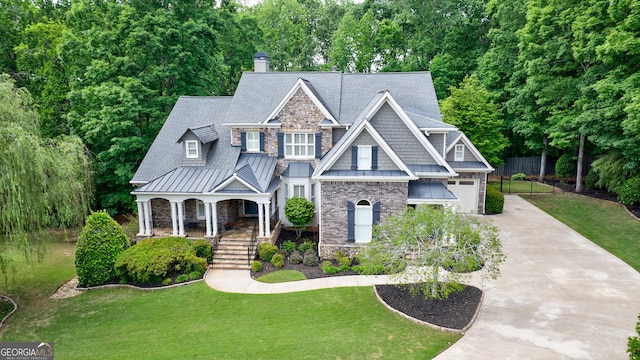 2101 Hunters Green Dr, Lawrenceville, GA 30043 - craftsman-style house featuring concrete driveway, a porch, a standing seam roof, stone siding, and a chimney
