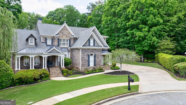 2101 Hunters Green Dr, Lawrenceville, GA 30043 - view of front facade featuring covered porch, a standing seam roof, driveway, and a front lawn