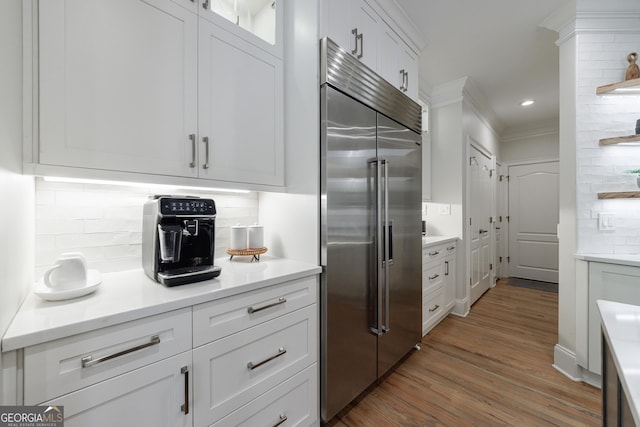 2101 Hunters Green Dr, Lawrenceville, GA 30043 - kitchen featuring built in refrigerator, tasteful backsplash, white cabinets, wood finished floors, and light countertops