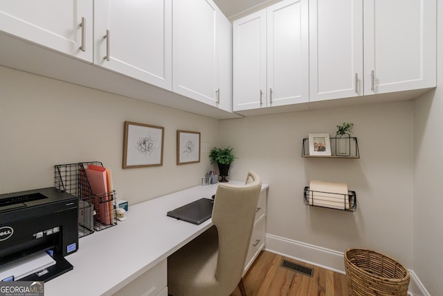 2101 Hunters Green Dr, Lawrenceville, GA 30043 - home office featuring baseboards, built in desk, and wood finished floors