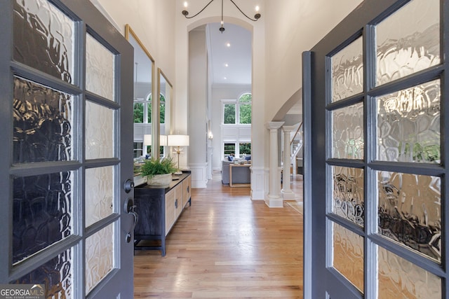 2101 Hunters Green Dr, Lawrenceville, GA 30043 - entryway with arched walkways, light wood finished floors, a decorative wall, ornamental molding, and a wainscoted wall
