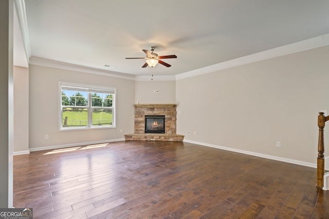 4650 Pleasant Woods Dr, Cumming, GA 30028 - unfurnished living room featuring ceiling fan, dark wood-style flooring, crown molding, baseboards, and a stone fireplace