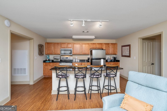 1523 Gadwall Way, Seneca, SC 29678 - kitchen with appliances with stainless steel finishes, a kitchen breakfast bar, light wood-type flooring, and dark countertops