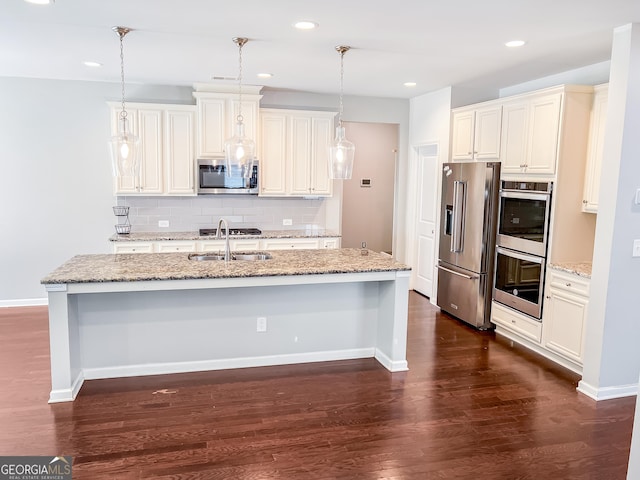 5229 Tye Trl, Fairburn, GA 30213 - kitchen with stainless steel appliances, an island with sink, dark wood finished floors, a sink, and decorative backsplash