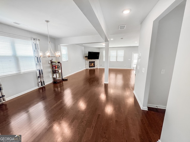5229 Tye Trl, Fairburn, GA 30213 - unfurnished living room featuring dark wood-style floors, a chandelier, baseboards, a stone fireplace, and recessed lighting