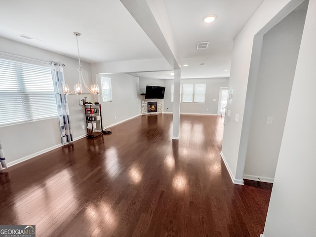 5229 Tye Trl, Fairburn, GA 30213 - unfurnished living room featuring dark wood-style floors, a chandelier, baseboards, a fireplace, and recessed lighting