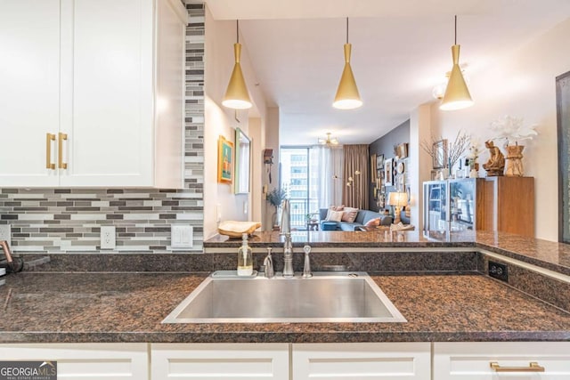 3040 Peachtree Rd NW Unit 1013, Atlanta, GA 30305 - kitchen with a sink, decorative backsplash, white cabinets, decorative light fixtures, and open floor plan