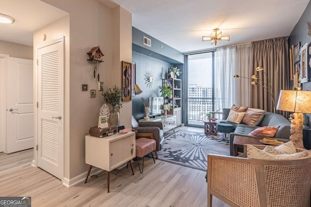 3040 Peachtree Rd NW Unit 1013, Atlanta, GA 30305 - living area with light wood-type flooring, floor to ceiling windows, baseboards, and a chandelier