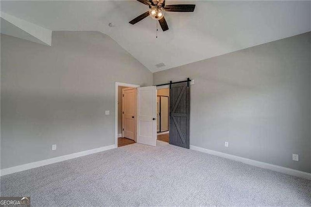 349 Creek Wood Park Dr, Ball Ground, GA 30107 - unfurnished bedroom with vaulted ceiling, carpet, a barn door, and a ceiling fan