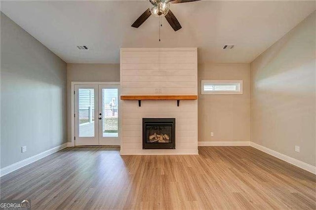 349 Creek Wood Park Dr, Ball Ground, GA 30107 - unfurnished living room with wood finished floors, ceiling fan, a large fireplace, and french doors