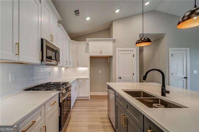 349 Creek Wood Park Dr, Ball Ground, GA 30107 - kitchen with stainless steel appliances, vaulted ceiling, white cabinetry, hanging light fixtures, and tasteful backsplash