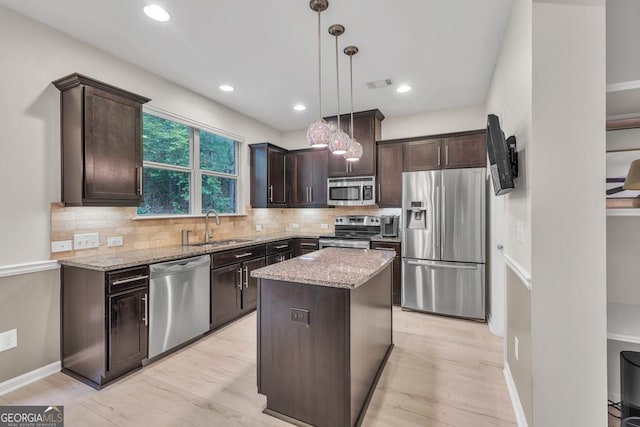 3982 Brockenhurst Dr, Buford, GA 30519 - kitchen with appliances with stainless steel finishes, a sink, dark brown cabinetry, light stone countertops, and backsplash