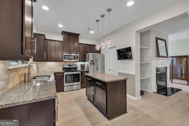 3982 Brockenhurst Dr, Buford, GA 30519 - kitchen featuring appliances with stainless steel finishes, a sink, dark brown cabinets, light stone countertops, and backsplash