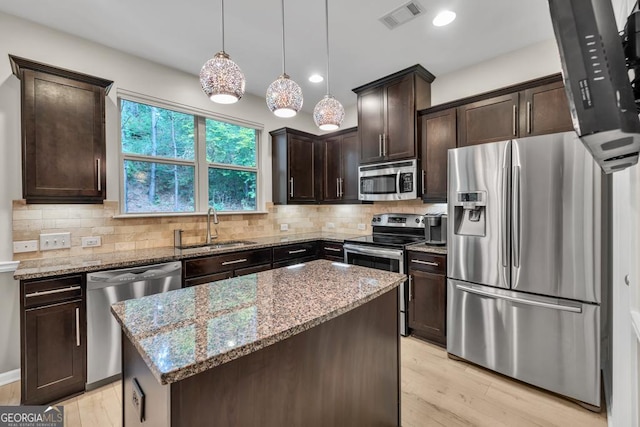 3982 Brockenhurst Dr, Buford, GA 30519 - kitchen featuring stainless steel appliances, a sink, dark brown cabinets, light stone counters, and recessed lighting